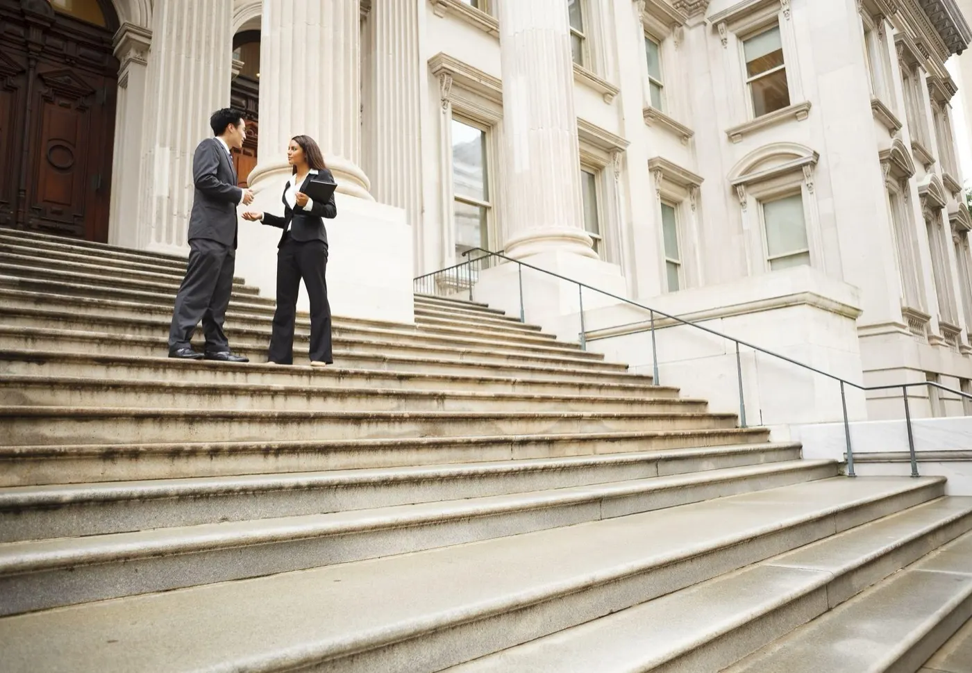 Two attorneys talking on courthouse steps